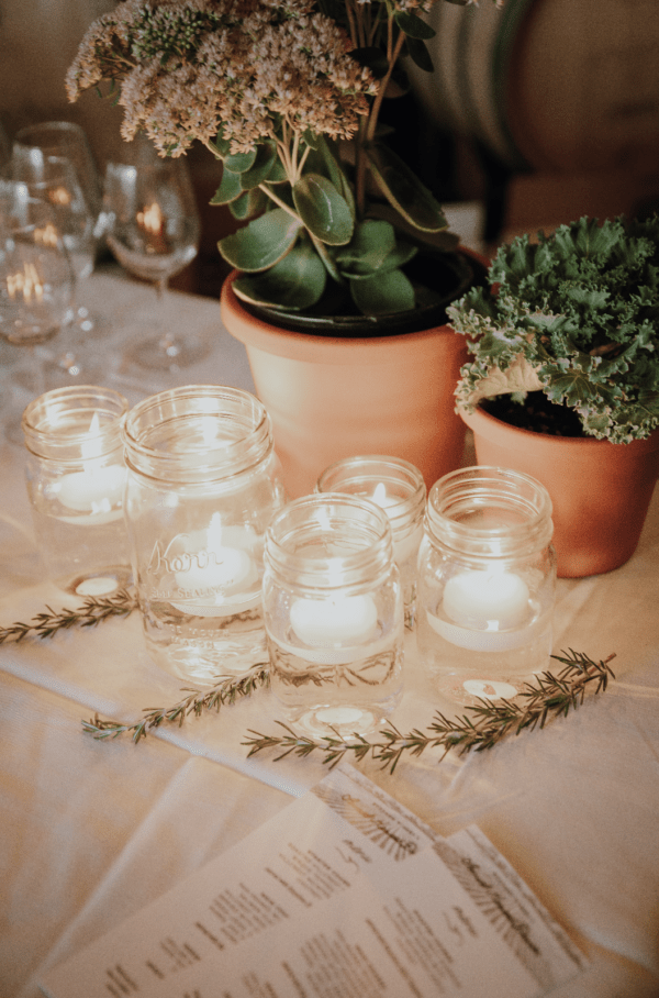 A photo of several glass jars full of water and floating white candles.